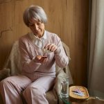 Elderly lady taking pills from chronic disease or multivitamins for health