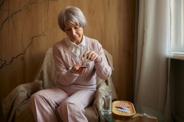 Elderly lady taking pills from chronic disease or multivitamins for health