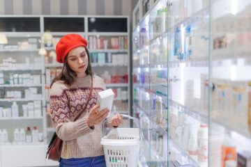 Young woman choosing a medication in pharmacy store.